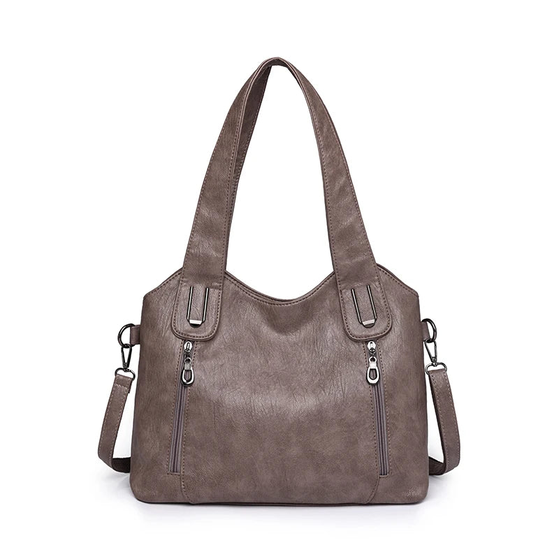 Brown handbag with multiple zippers on a white background