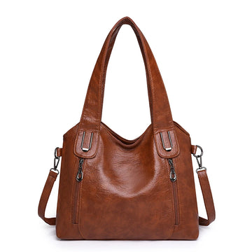 Brown leather handbag with shoulder strap on a white background