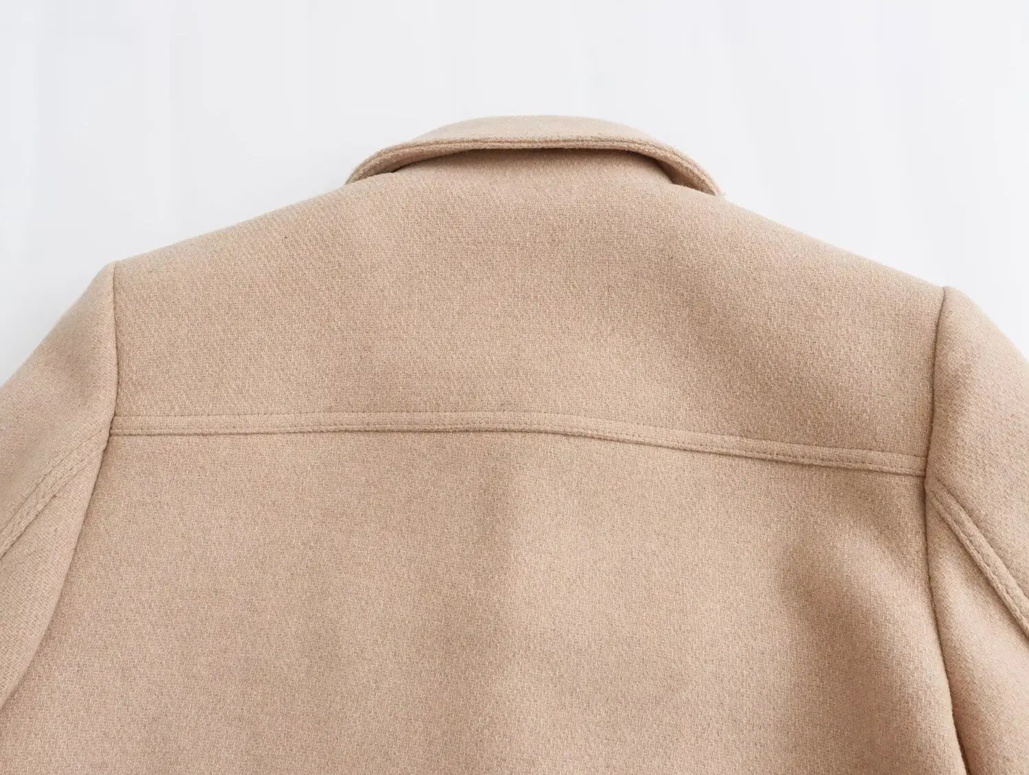 Close-up of a beige coat on a light gray background