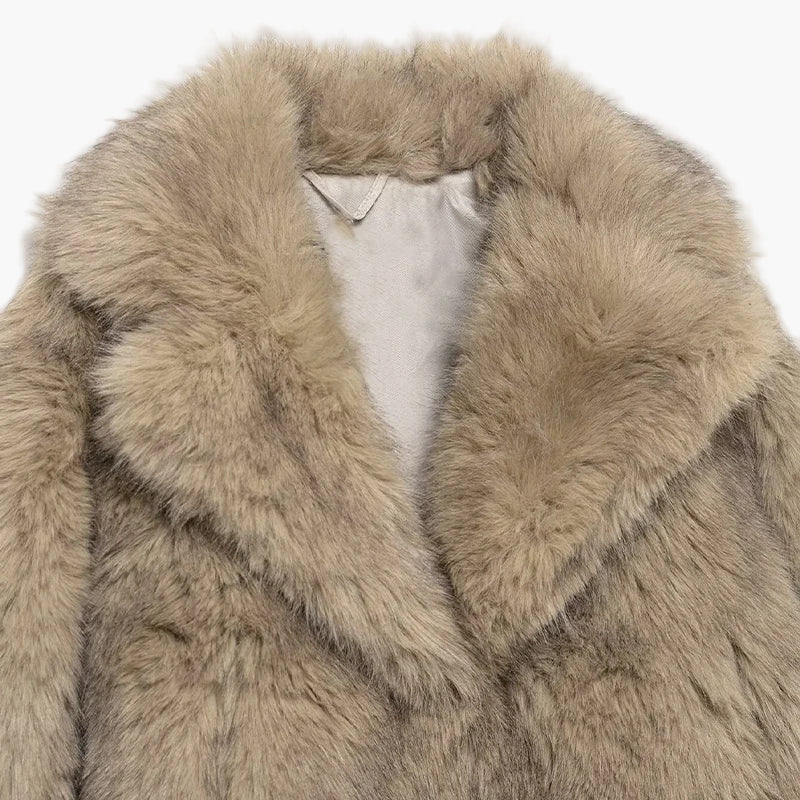 Close-up of a beige fur coat with a white label on a white background
