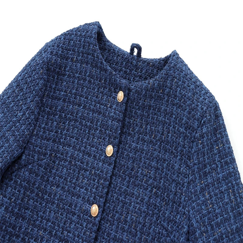 Close-up of a blue textured fabric with gold buttons on a white background