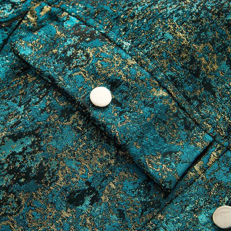 Close-up of a textured teal fabric with gold accents and a button.