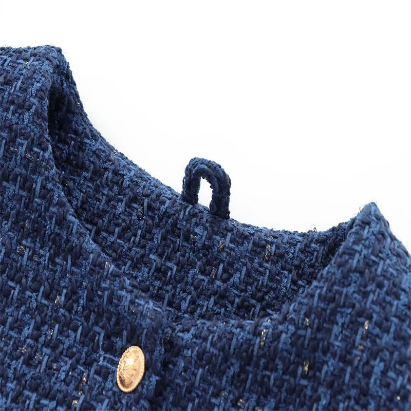 Close-up of a blue textured fabric with a button on a white background