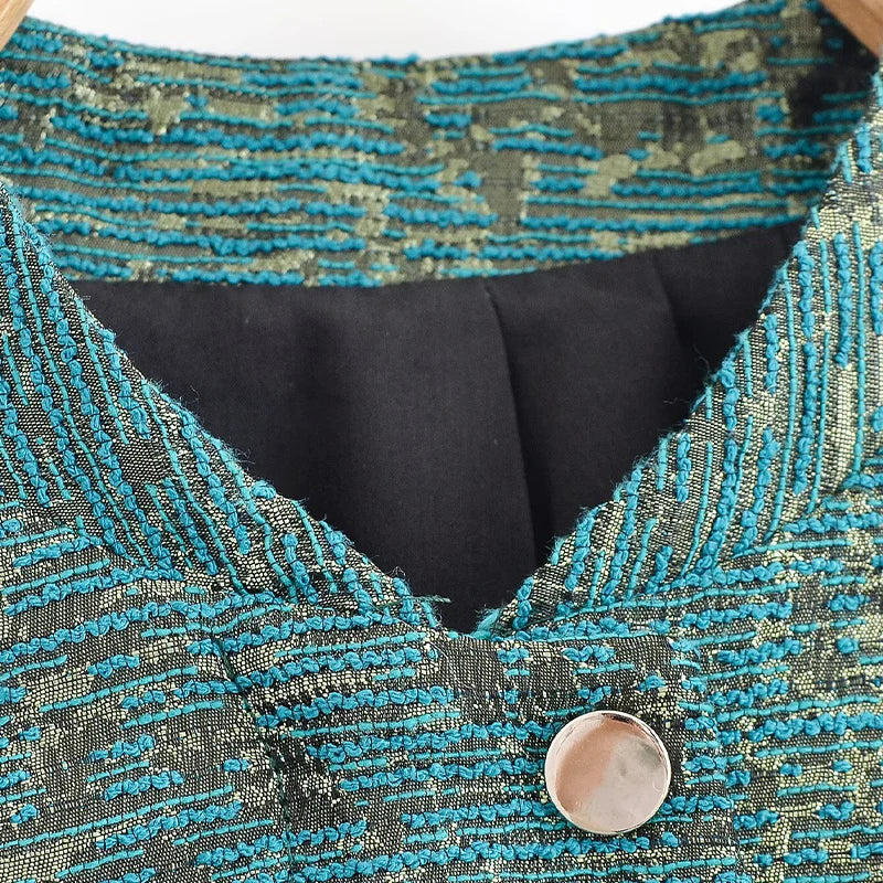 Close-up of a textured blue and black garment with a button.