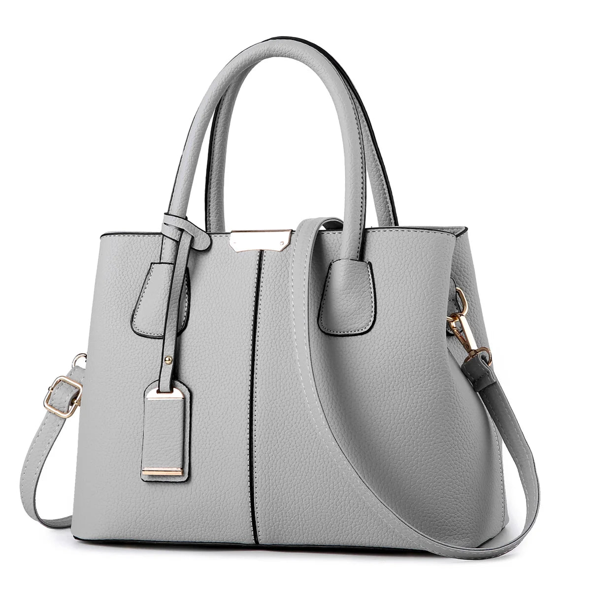 Model carrying an elegant tan shoulder bag while walking through an urban street in a tailored coat.