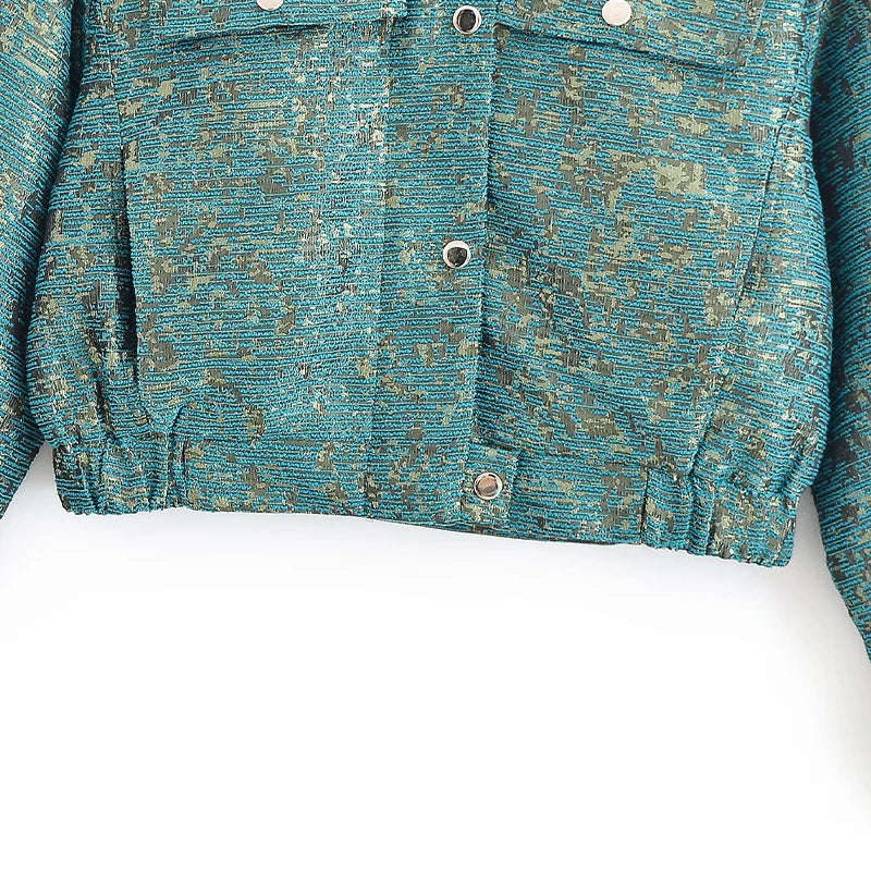 Close-up of a textured teal jacket with buttons on a white background