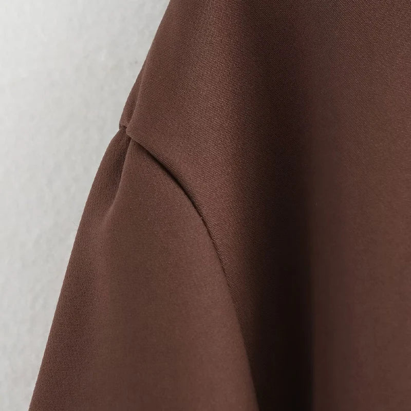 Close-up of brown fabric with a textured surface on a light gray background