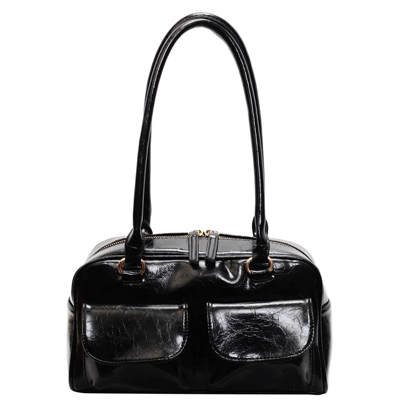 Black handbag with a glossy finish on a white background