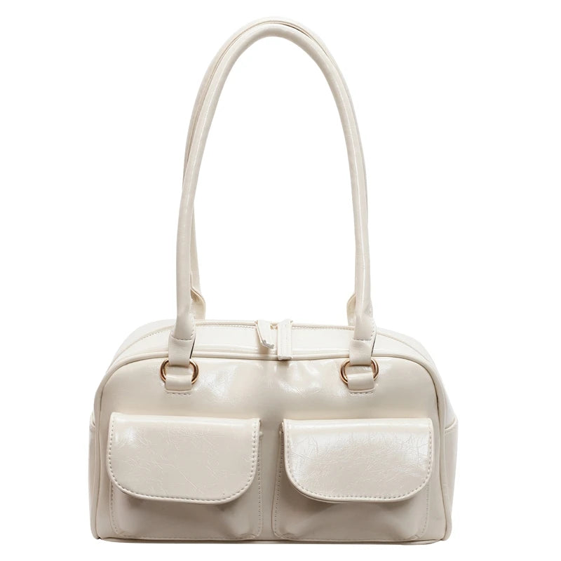 Beige handbag with two front pockets on a white background