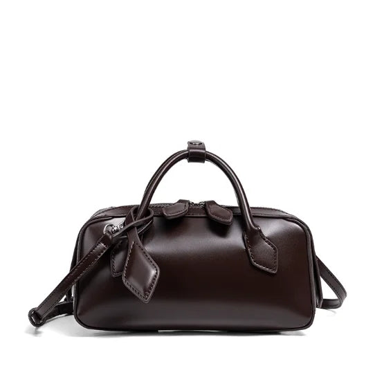 Brown leather handbag with a strap on a white background
