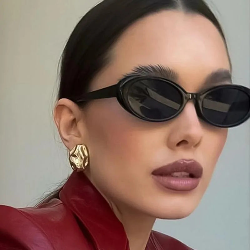 Retro Chic Oval Shades with Close-up of a person wearing black sunglasses and a red jacket with a neutral background