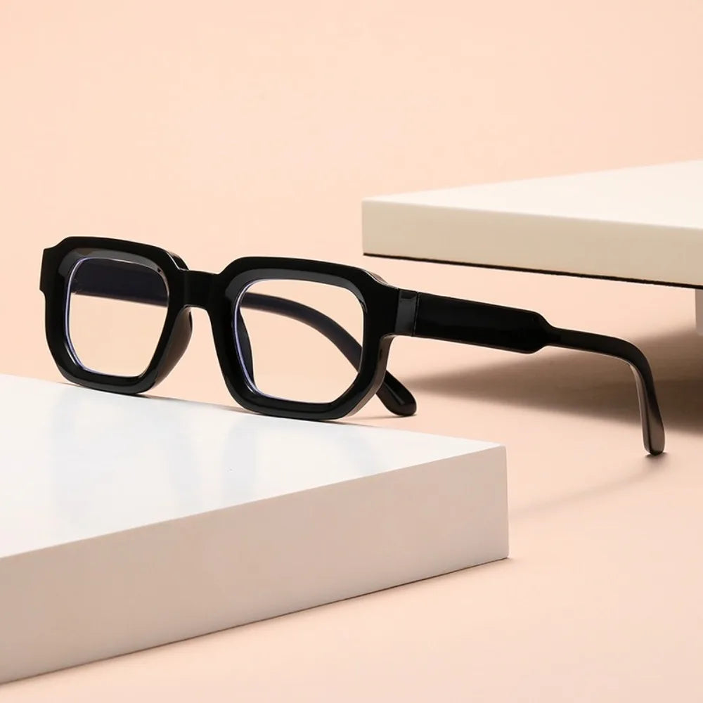 Leopard Punk Square Shades Black eyeglasses on a beige surface with a white box