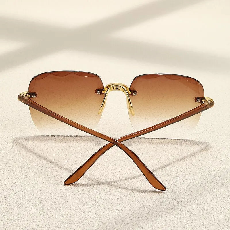 Crossed sunglasses with brown gradient lenses on aClassic Gradient Glow Shades