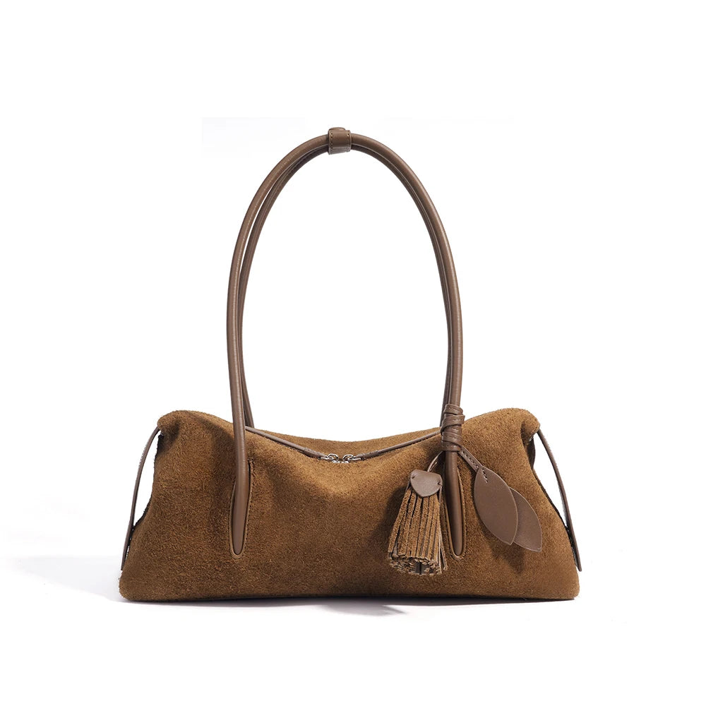 Brown handbag with leather handle and tassel on a white background