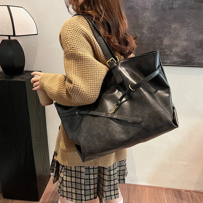 Person wearing a large black leather backpack indoors.